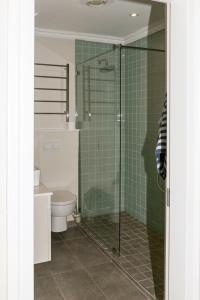 a bathroom with a toilet and a glass shower at Waterfront - 10 Spinniker Knysna Quays in Knysna