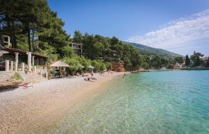 a beach with a group of people sitting on the shore at Apartments Laguna 2 in Bol