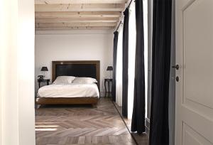 a bedroom with a bed and a wooden floor at La Locanda alla Stazione in Ponte nellʼAlpi
