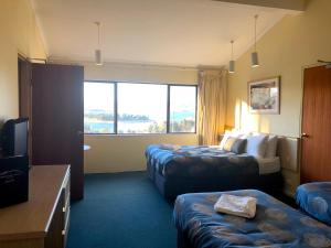金逹拜恩的住宿－高山度假汽車旅館，酒店客房设有两张床和窗户。