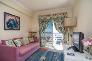 a living room with a purple couch and a tv at Setubal Dreams in Setúbal