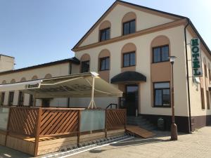 un bâtiment avec un parasol devant lui dans l'établissement Hotel pod Hůrkou, à Háj ve Slezsku