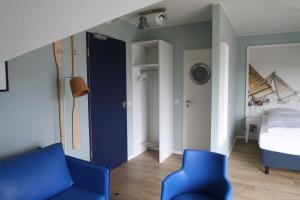 a bedroom with a blue couch and a bed at Havelhotel in Brandenburg an der Havel