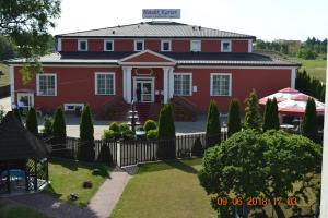 a red house with a fence in front of it at Hotelik Karter in Warsaw