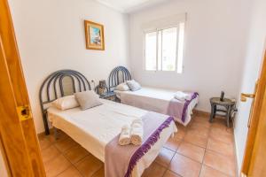 プレヤス・デ・オリフエラにあるVilla Cabo Roigのベッドルーム1室(ベッド2台、窓付)