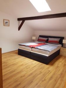 a bedroom with a bed and a wooden floor at Jujhar's Gästehaus in Wasserburg am Inn