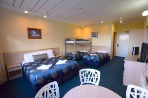 a hotel room with two beds and a table and chairs at Alpine Resort Motel in Jindabyne
