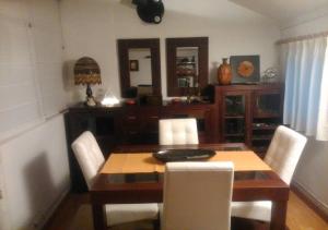 Un comedor con una mesa de madera y sillas blancas. en Apartamento El Cielo de Jesi, en León