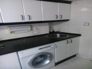 a kitchen with a washing machine and a sink at Apartamento El Cielo de Jesi in León