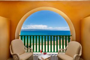 a balcony with two chairs and a view of the ocean at Hotel Dei Pini in Alghero