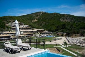 a view of a resort with two chairs and a pool at Thassos Grand Resort in Alyki