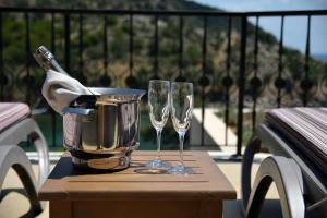 two wine glasses and a bucket on a table at Thassos Grand Resort in Alyki
