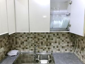 a kitchen with white cabinets and a sink at EKA Luxury One-Bedroom Apartment in Durrës +10 photos