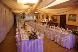 a row of tables in a banquet hall with white chairs at Hotel Wald in Warsaw
