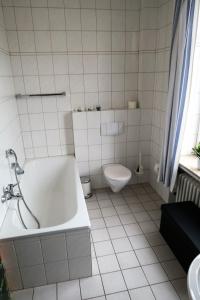 La salle de bains blanche est pourvue d'une baignoire et de toilettes. dans l'établissement Hotel-Restaurant Haus Keller, à Laggenbeck