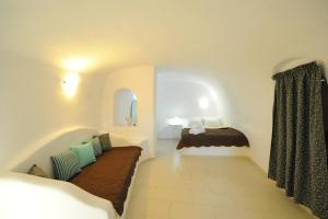 a small room with a bed and a window at Manias Fira Residences in Fira