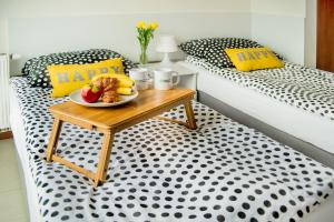 a table with a plate of food on a bed at Apartament Kniaziewicza - Komfortowe Noclegi in Piaseczno