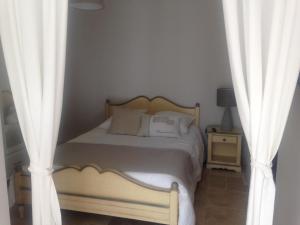 1 dormitorio con 1 cama con cortinas blancas en La Petite perle, balnéo en supplément, le Clos des Perles, en Tourtour