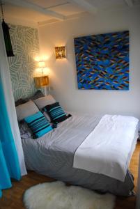 レオンにあるLes Villages sous les Pins, piscines chauffées, Les Arbousiersのベッドルーム1室(壁に絵画が描かれたベッド1台付)
