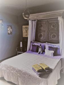 una camera viola con un grande letto con due cuscini di Agriturismo Gocce di Luna a Celle Ligure