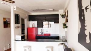 a kitchen with a red refrigerator and black cabinets at Seafront Golden Mile Las Americas Hard Rock in Arona