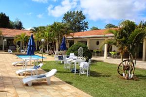 a patio with chairs and tables and a pool at Hotel Brisa do Japi in Cabreúva