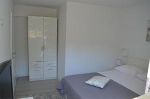 um quarto branco com uma cama e um closet em Apartman Talija em Kali
