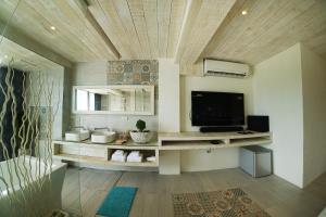ein Wohnzimmer mit einem Flachbild-TV an einer Holzdecke in der Unterkunft 湛藍海岸民宿 Azure--這個夏天有點藍--墾丁南灣沙灘-可包棟-國旅卡特約店 in Nanwan