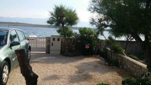 a car parked in a driveway next to the water at Apartman Mara in Vir