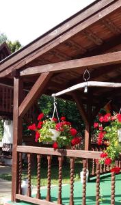 a wooden pergola with flowers on it at Osho Vendégház in Tiszafüred