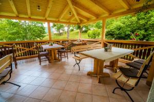 a porch with tables and chairs on a wooden deck at Bed & Breakfast Hisa Resje in Bohinj