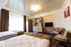 a hotel room with two beds and a television at White Tower Mamaia in Mamaia +39 photos
