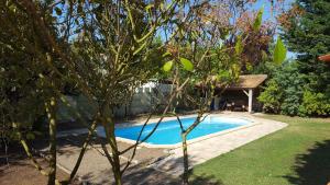 a swimming pool in a yard with a tree at La Closeraie in Champagné-les-Marais +20 photos