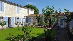 a house with a lawn in front of it at La Closeraie in Champagné-les-Marais