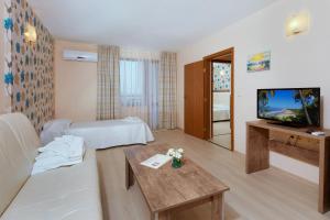 a hotel room with a bed and a television at Relax Holiday Complex & Spa in Sunny Beach