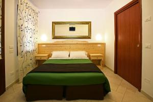 1 dormitorio con cama verde y espejo en La Brenta Vecchia, en Vigodarzere