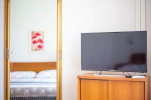 TV de pantalla plana en la parte superior de un armario de madera en Vila Niko, en Makarska