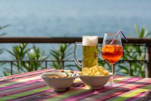 einen Tisch mit einem Glas Bier und einer Schale Chips in der Unterkunft Hotel Residence Sirenella in Torri del Benaco