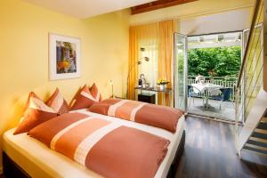 a bedroom with a large bed and a balcony at Hallwil Swiss Quality Seehotel in Beinwil