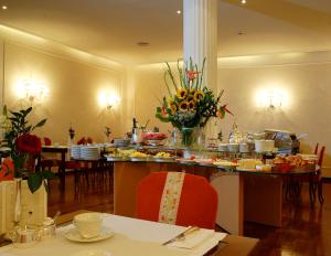 jadalnia ze stołem i talerzami z jedzeniem w obiekcie Hotel De La Ville we Florencji