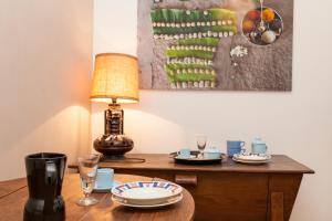 a table with a lamp and plates and glasses on it at 46FM : Montauban Guest House in Montauban