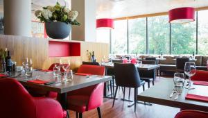 un restaurante con mesas y sillas y copas de vino en Bastion Hotel Amsterdam Amstel, en Ámsterdam