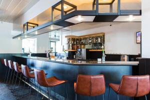 a bar with leather chairs at a restaurant at Bastion Hotel Amsterdam Amstel in Amsterdam