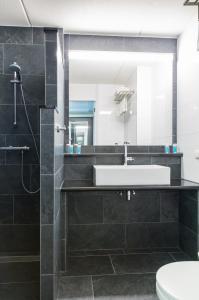 een badkamer met een wastafel en een spiegel bij Bastion Hotel Amsterdam Amstel in Amsterdam