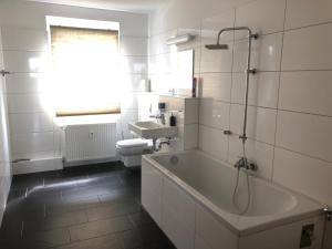 a bathroom with a tub and a toilet and a sink at Apartment vor Magdeburg in Gerwisch