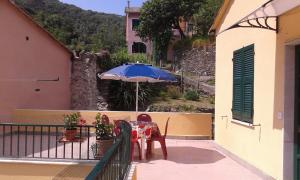 a table with a blue umbrella on a balcony at Casa Del Mulino in Levanto +20 photos
