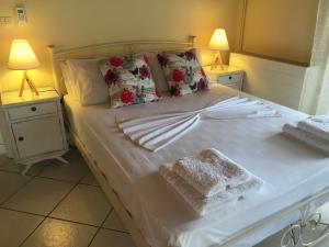 1 cama blanca con 2 almohadas y toallas en Alexandra' s Village House, en Kato Korakiana