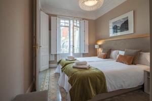 バルセロナにあるHabitat Apartments Barcelona Classicのベッドルーム1室(ベッド2台、窓付)