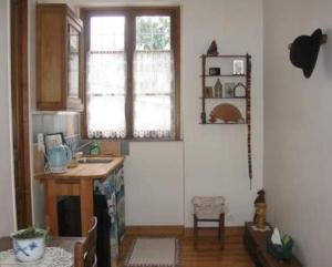 uma cozinha com um lavatório, uma mesa e uma janela em Chambres d'hôtes Haut de Belleville em Paris
