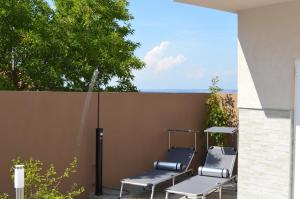 eine Terrasse mit 2 Stühlen und einem Brunnen in der Unterkunft Apartman Talija in Kali